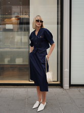 a lady in denim v-neck top and matching midi skirt